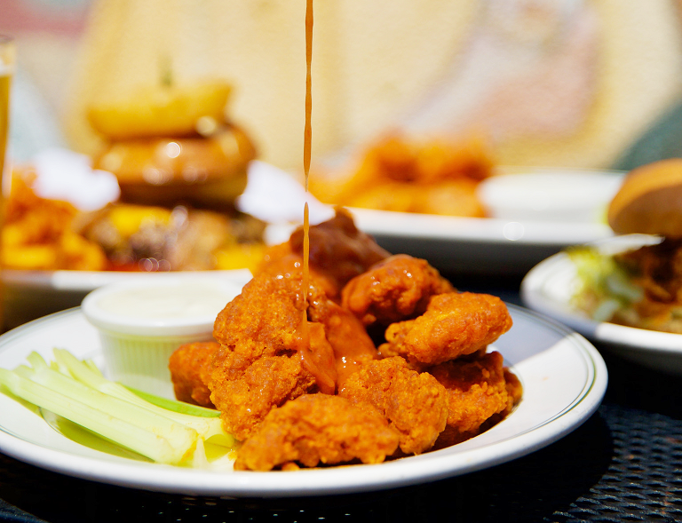 Sauce being poured over the best wings in town