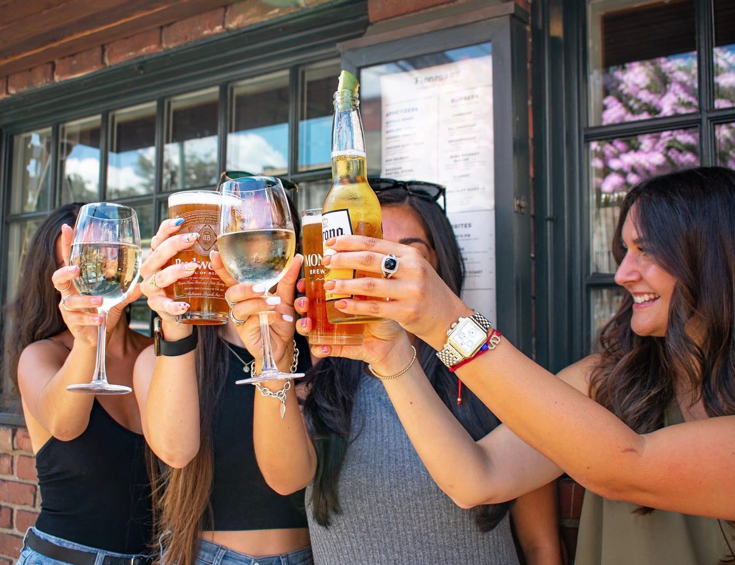 Four women toasting their drinks at happy hour