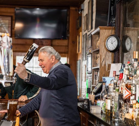 A bartender serving drinks at Finnegan's during happy hour